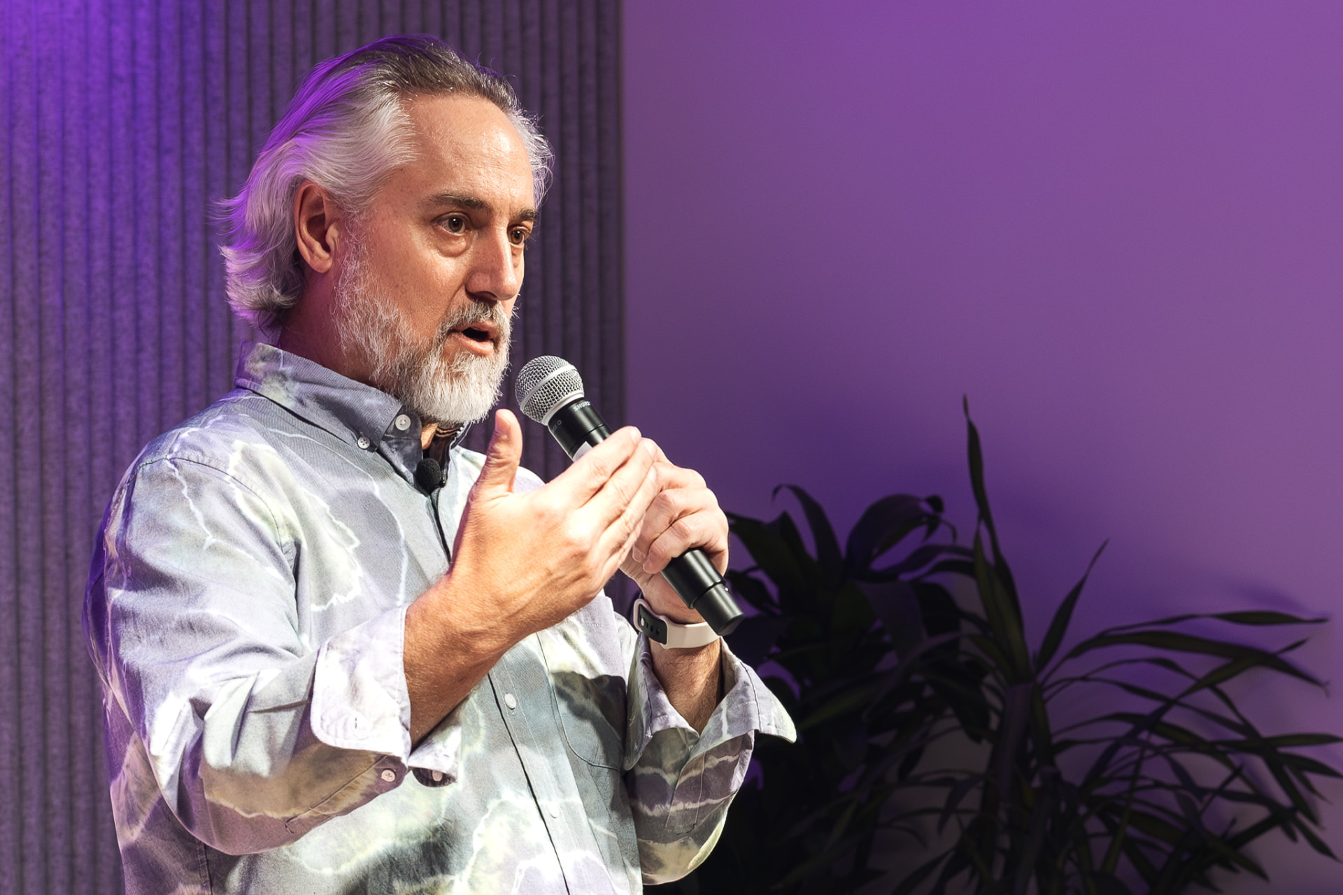 Stuart Preston speaking on stage with a microphone
